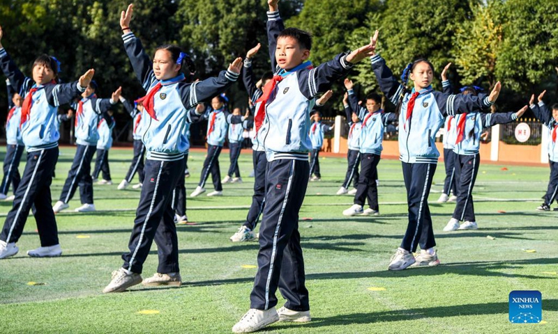 Photo taken on Dec. 1, 2021 shows children performing group calisthenics in Binhu Road Primary School in Nanning, south China's Guangxi Zhuang Autonomous Region. On Dec. 1, the Binhu Road Primary School held the opening ceremony of sports culture festival. A number of activities were held for the festival, such as group calisthenics performances and sports competitions. This allows the children to get out of the classroom, enjoy the sunshine, and partake in the joy of sports.(Photo: Xinhua)