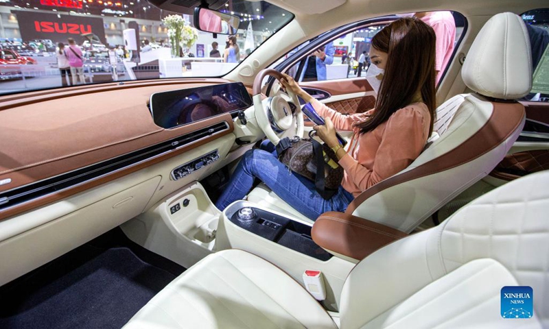 A visitor experiences an ORA Good Cat electric car during the Thailand International Motor Expo 2021 in Bangkok, Thailand, Dec. 1, 2021. The Motor Expo kicked off on Dec. 1 and will last until Dec. 12, showcasing 32 car brands and 12 motorcycle brands as well as electric vehicles.(Photo: Xinhua)