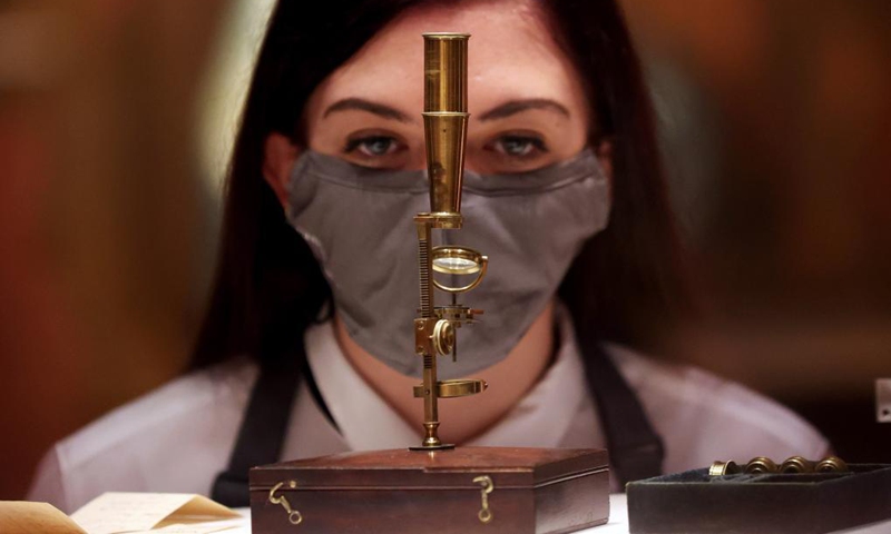 A staff member checks the Charles Darwin Family Microscope for auction during a media preview of the Christie's London Classic Week auction in London, Britain, Dec. 3, 2021. Christie's London Classic Week presents art from antiquity to the 21st century, spanning five live auctions and four online-only sales.Photo:Xinhua