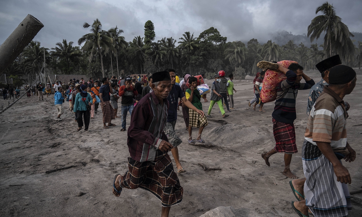 Villagers salvage their belongings in an area covered in volcanic ash at Sumber Wuluh village in Lumajang, Indonesia on December 5, 2021. Photo: AFP
