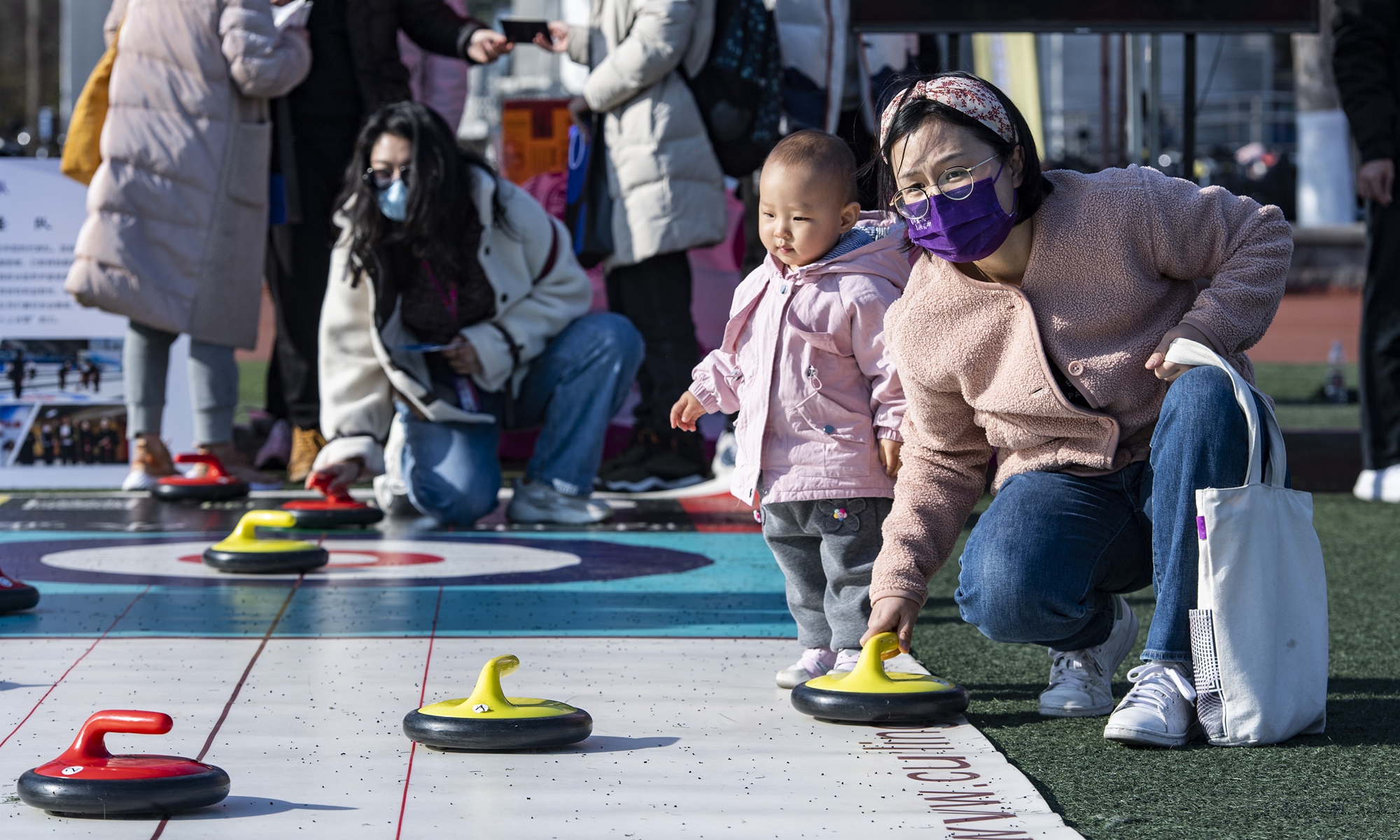 Parents and children play floor curling at a playground in Tsinghua University on December 5, 2021. The university held a series of activities to spread Winter Olympics culture. Photo: VCG