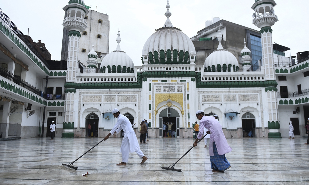 Muslim devotees remove water after a rainfall before others arrive to offer morning prayers on the occasion of the Eid al-Adha or the Festival of Sacrifice, at Jama Masjid Khairuddin in Amritsar, India on July 21, 2021. Photo: AFP