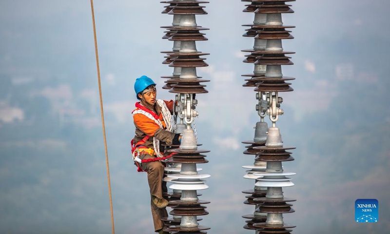 Photo taken on Dec. 5, 2021 shows a utility technician working at the construction site of the Chongqing section of the Baihetan-Jiangsu ultra-high-voltage (UHV) power transmission project over the Yangtze River in southwest China's Chongqing Municipality.Photo:Xinhua