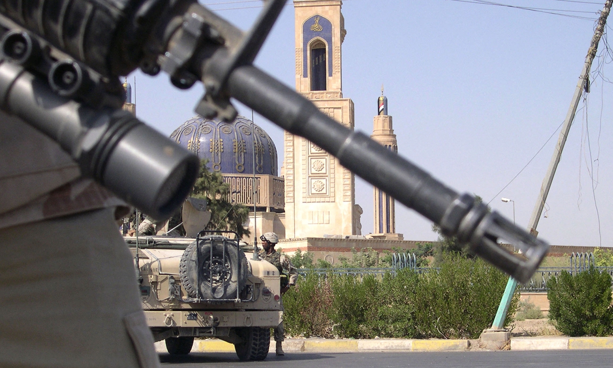 US soldiers cordon off the area due to a bomb threat following the Friday noon prayers at the Umm Qura mosque, the headquarters of the Association of Islamic Scholars, in west Baghdad 08 October 2004.  Photo: AFP 