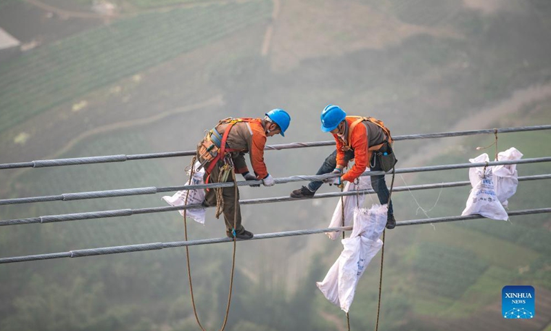Photo taken on Dec. 5, 2021 shows a utility technician working at the construction site of the Chongqing section of the Baihetan-Jiangsu ultra-high-voltage (UHV) power transmission project over the Yangtze River in southwest China's Chongqing Municipality.Photo:Xinhua