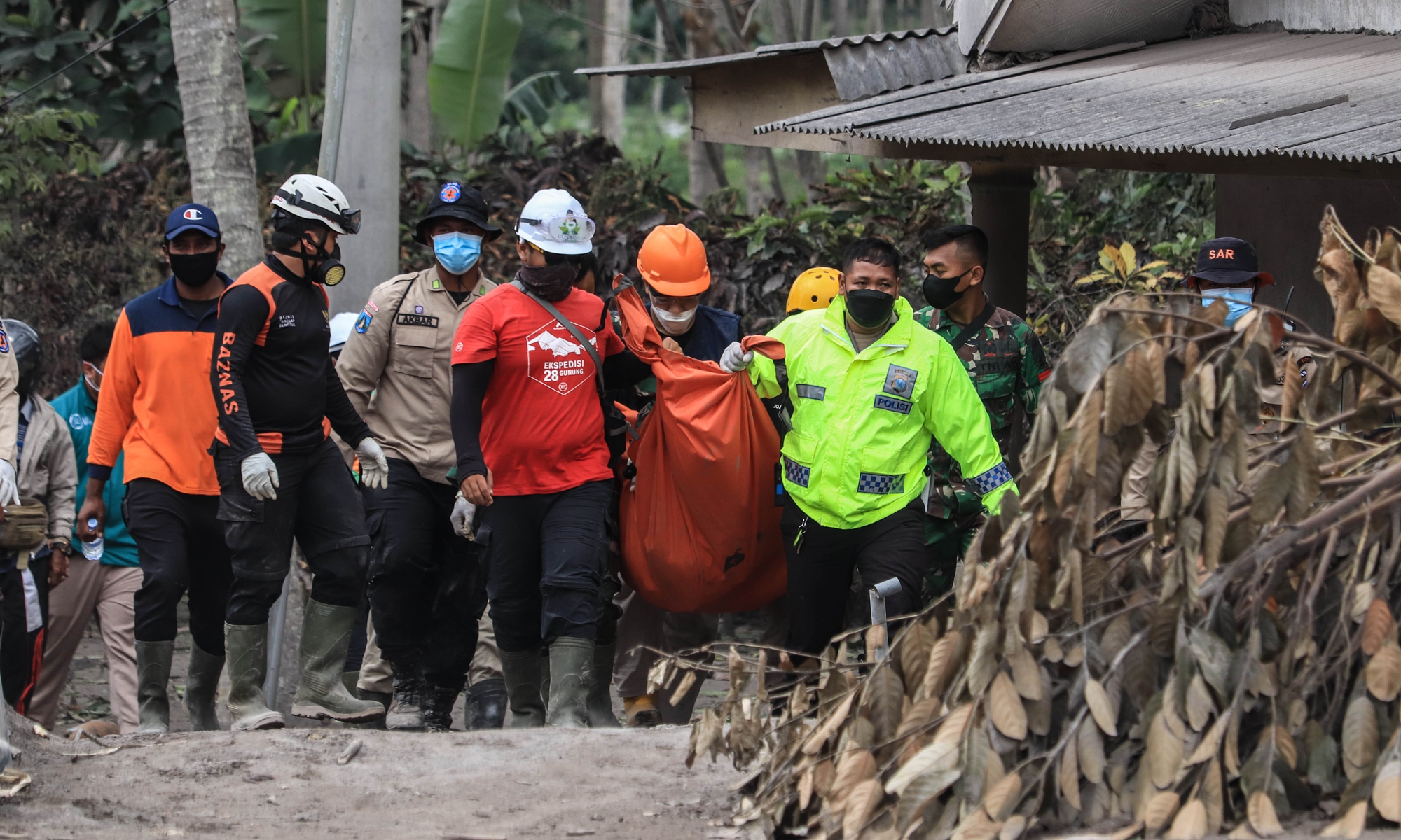 Rescue teams and residents carry dead victims of the Mount Semeru eruption in Sumberwuluh Village, Lumajang, East Java, on December 6, 2021. Photo: VCG