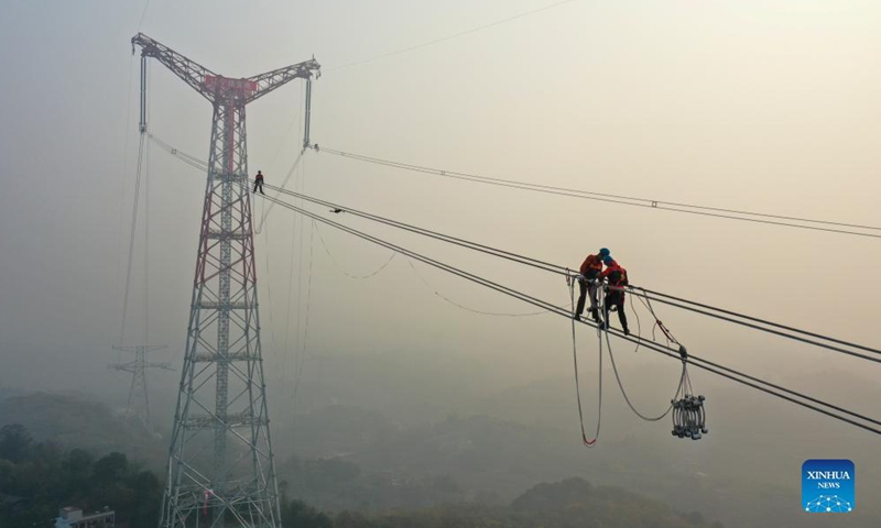 Photo taken on Dec. 5, 2021 shows a utility technician working at the construction site of the Chongqing section of the Baihetan-Jiangsu ultra-high-voltage (UHV) power transmission project over the Yangtze River in southwest China's Chongqing Municipality.Photo:Xinhua