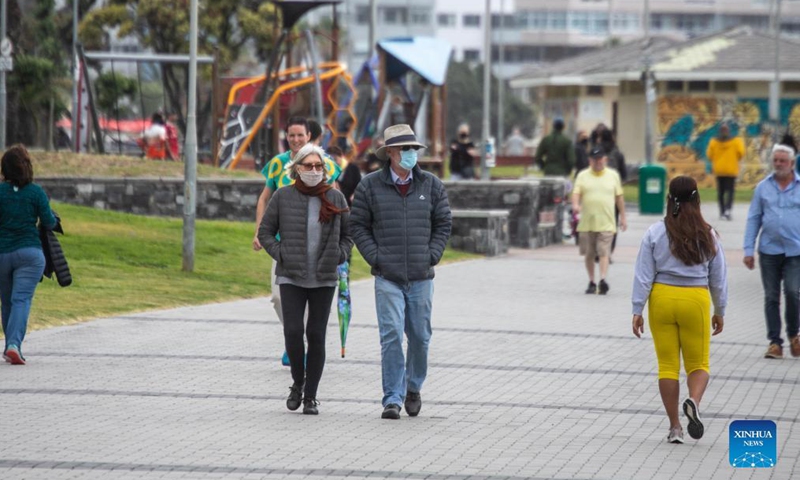 Pedestrians wearing face masks walk on the seaside in Cape Town, South Africa, Dec. 5, 2021.Photo:Xinhua