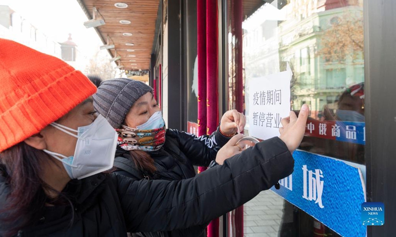 Staff members put up a notice saying that their store is temporarily closed on the Central Street in Harbin, northeast China's Heilongjiang Province, Dec. 5, 2021.Photo:Xinhua