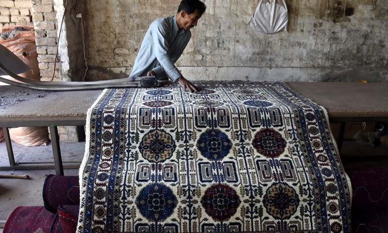 A worker makes a carpet at a local carpet factory on the outskirts of Peshawar, Pakistan, Dec. 6, 2021.(Photo: Xinhua)