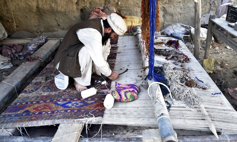 A worker weaves a carpet at a local carpet factory on the outskirts of Peshawar, Pakistan, Dec. 6, 2021. (Photo: Xinhua)