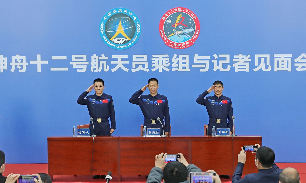 (From left to right) Tang Hongbo, Nie Haisheng and Liu Boming - the Shenzhou-12 crew - stand and salute at a media conference held on December 7, 2021 in Beijing. Photo: courtesy of our space