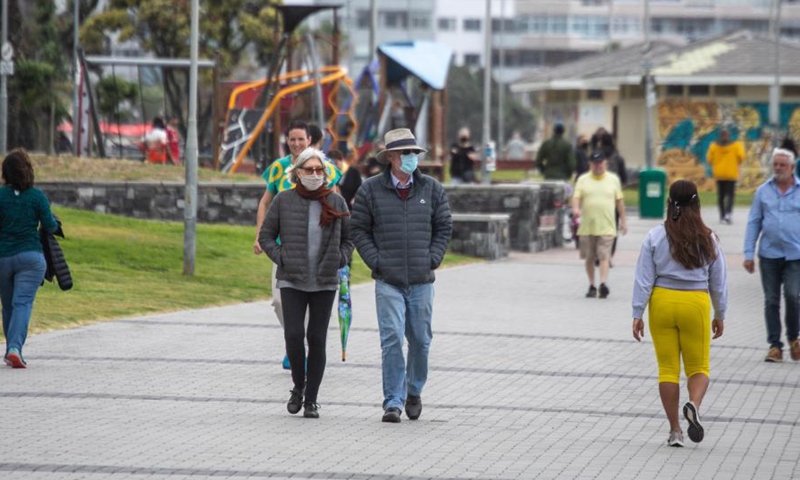 Pedestrians wearing face masks walk on the seaside in Cape Town, South Africa, Dec. 5, 2021.(Photo: Xinhua)