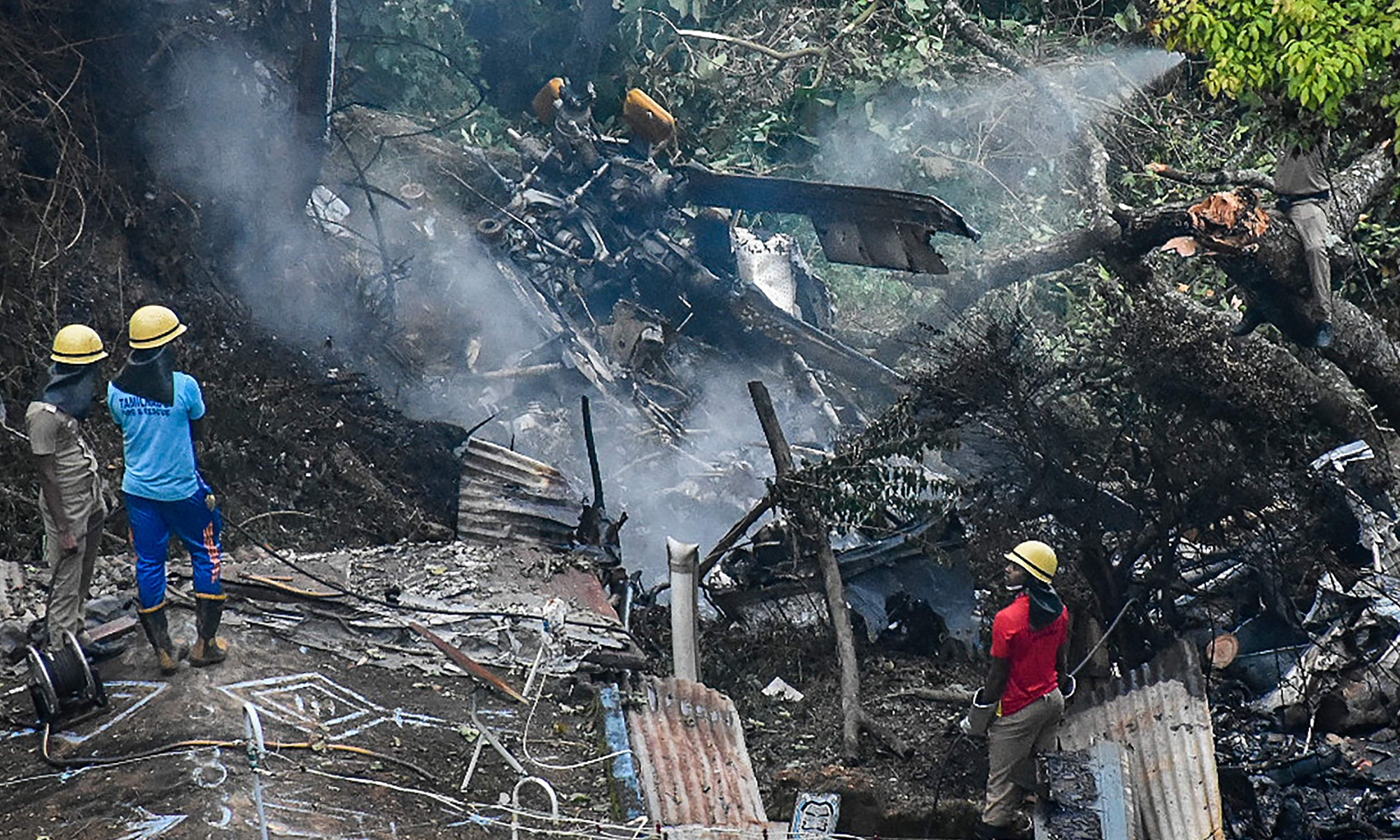 Firemen and rescue workers look at the debris of an IAF Mi-17V5 helicopter crash site in Coonoor, Tamil Nadu, on December 8, 2021. A helicopter carrying India's defense chief General Bipin Rawat crashed, the air force said, with a government minister at the scene saying at least 13 people were killed. Photo: VCG