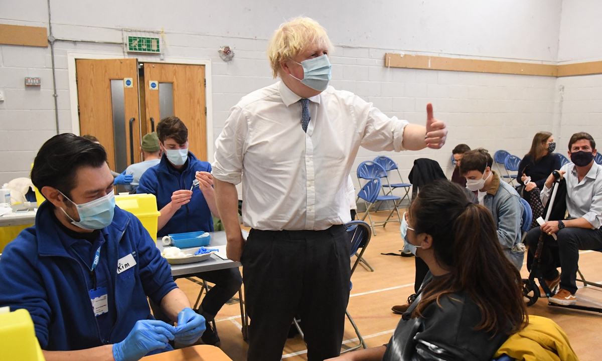 British Prime Minister Boris Johnson visits a vaccination center in London on December 13, 2021. Johnson said the Omicron variant has caused at least one death in the UK when he warns of a looming 