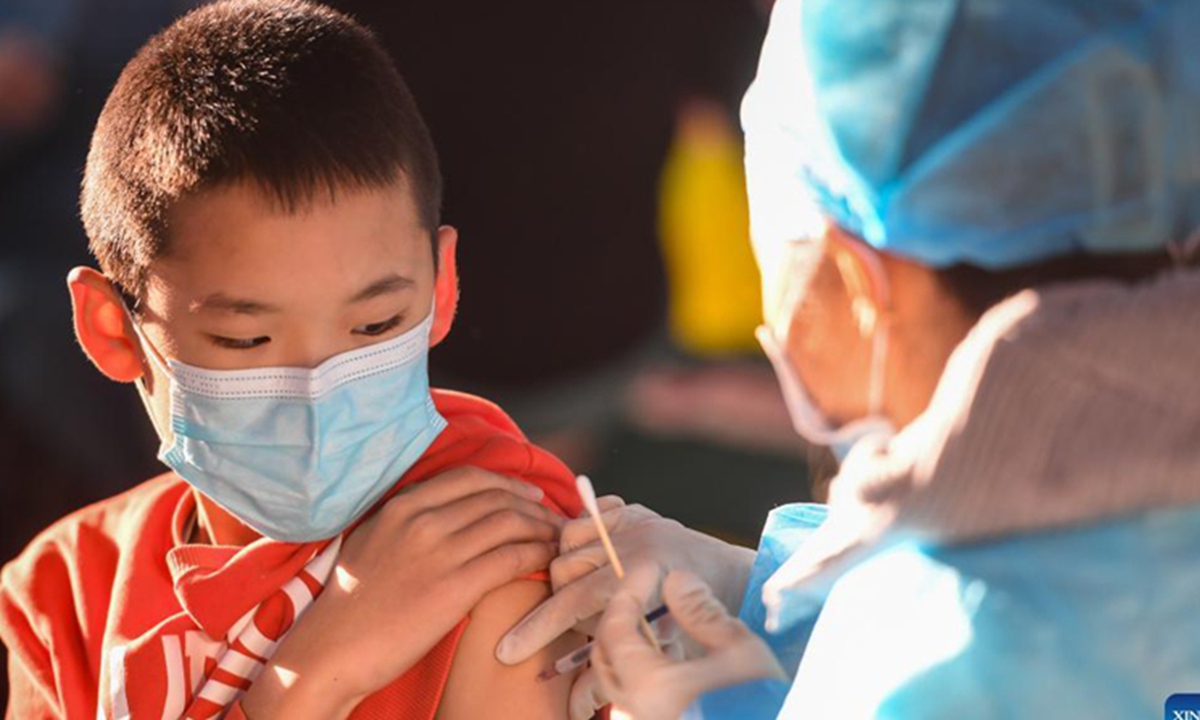 A kid receives a dose of COVID-19 vaccine at a school in Hohhot, north China's Inner Mongolia Autonomous Region, Nov. 23, 2021. Hohhot recently launched a COVID-19 vaccination campaign for children aged 3 to 11. Photo: Xinhua