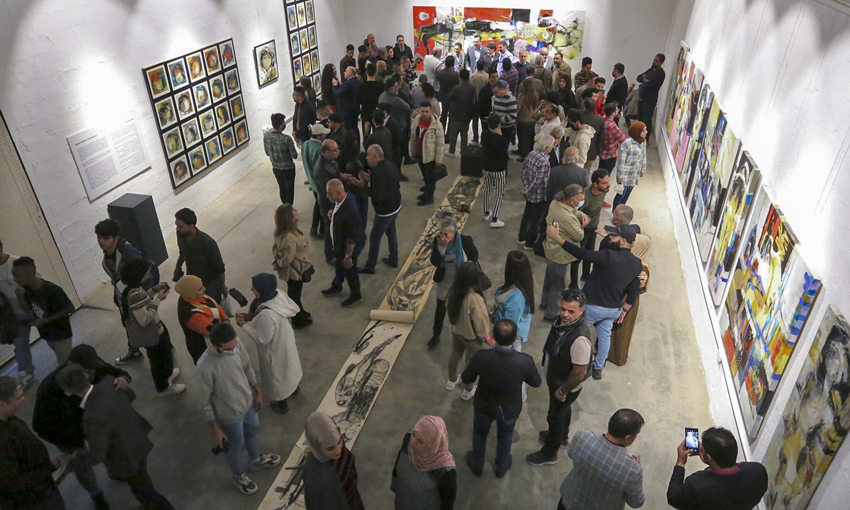 Visitors attend the opening of an exhibition by plastic artist Riyadh Ghenea in the Iraqi capital of Baghdad on November 26, 2021. Photo: AFP