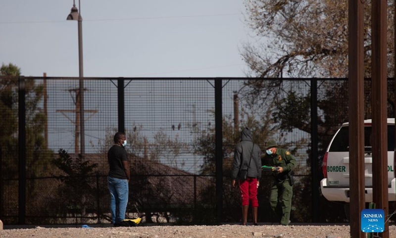 A U.S. Border Patrol agent inspects migrants who came from Ciudad Juarez, Mexico, near the U.S.-Mexico border on Dec. 7, 2021.(Photo: Xinhua)