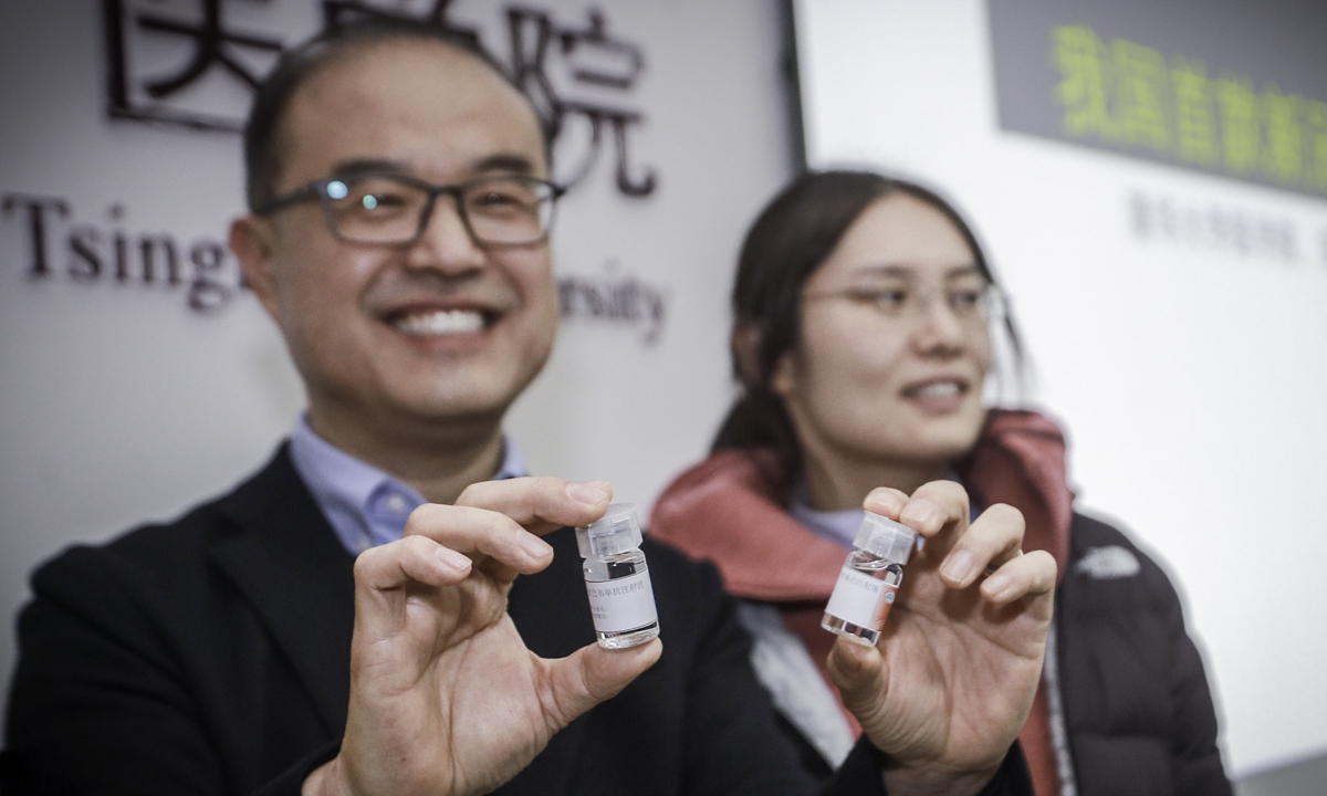 Zhang Linqi (left) of the Tsinghua University School of Medicine shows the newly approved anti-COVID-19 drug at a press conference in Beijing on December 9, 2021. Zhang led the research and development of the drug. Photo: cnsphoto