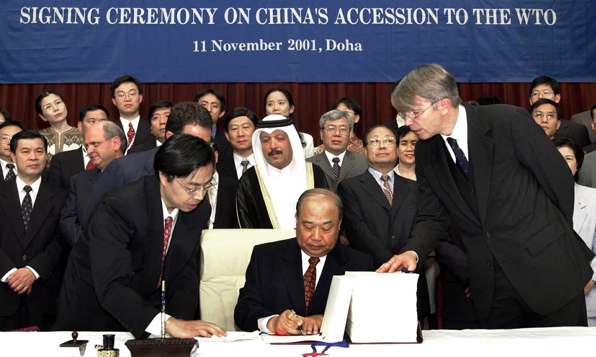 Shi Guangsheng (center), head of the Chinese delegation and then Chinese Minister of Foreign Trade and Economic Cooperation, signs documents at the signing ceremony of China's accession to the WTO in Doha, Qatar, on November 11, 2001. Photo: VCG