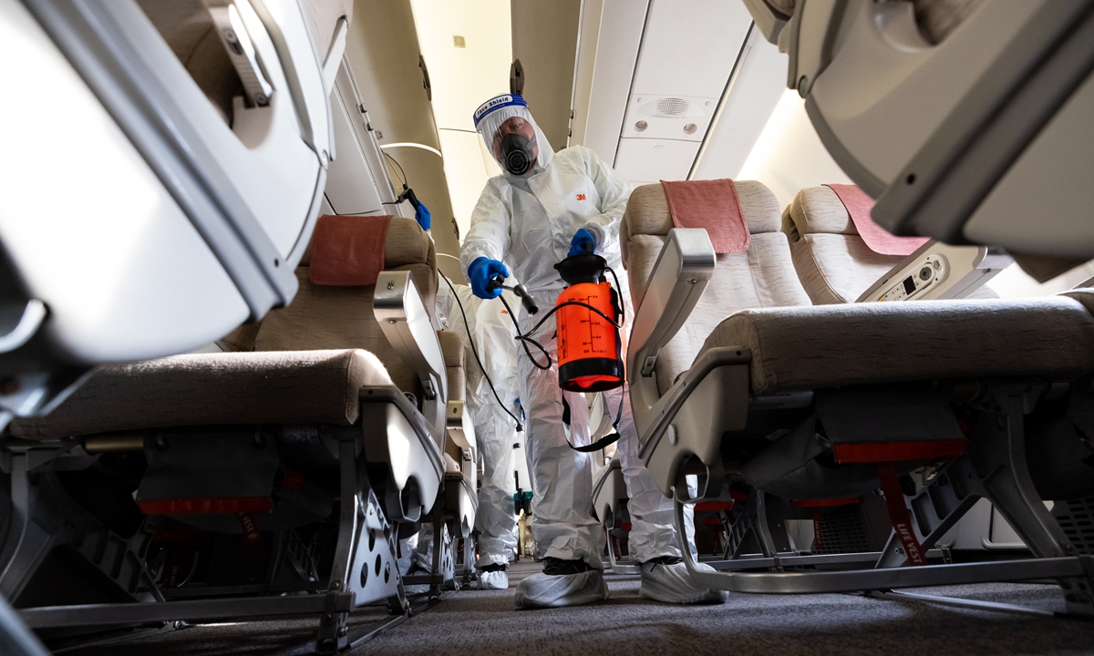 A worker wearing personal protective equipment sprays disinfectant inside an aircraft at Incheon International Airport in Incheon, South Korea on December 9, 2021. Photo: VCG