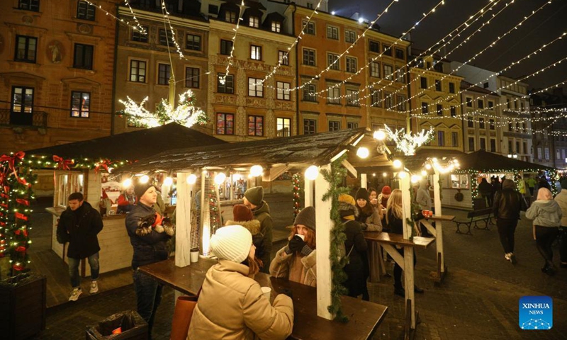 People enjoy mulled wine at the Old Market Square in Warsaw, Poland, Dec. 7, 2021. Every year the Old Town in the city is decorated with thousands of objects in different colors of lights for the Christmas season.Photo:Xinhua
