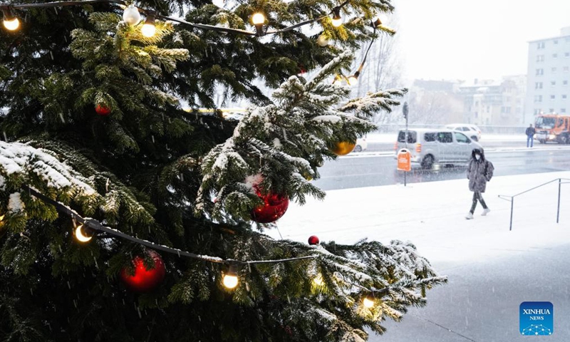 A pedestrian walks past a snow-covered Christmas tree in Berlin, capital of Germany, Dec. 9, 2021.Photo:Xinhua