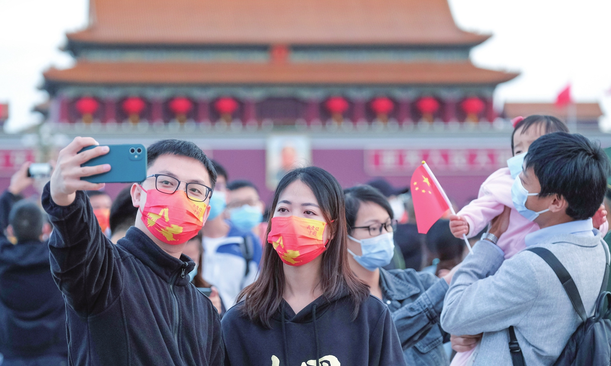 Two young people take a selfie at Tiananmen Square on the morning of October 1, 2021 after the flag-raising ceremony. More than 130,000 people came to the square to celebrate the 72nd anniversary of the founding of the People's Republic of China on the day. Photo: VCG