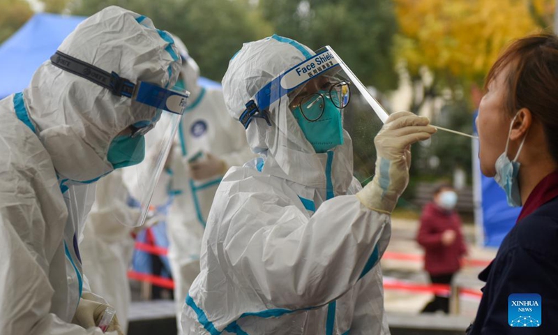 A medical worker takes a swab sample from a resident for nucleic acid test in Huangjiabu Township of Yuyao City, east China's Zhejiang Province, Dec. 12, 2021.Photo:Xinhua