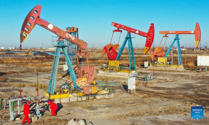 Aerial photo taken on Dec. 12, 2021 shows workers inspecting an oil well at Jidong Oilfield in north China's Hebei Province.Photo:Xinhua