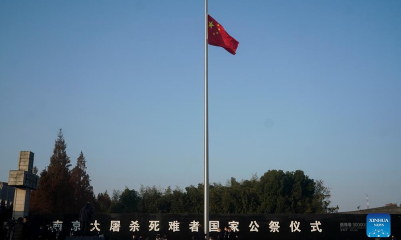 中国の国旗は、2021年12月13日、中国東部の江蘇省の首都である南京の日本の侵略者による南京大虐殺犠牲者記念館での南京大虐殺の犠牲者のための国家記念式典の前に半旗ではためく. 写真: 新華社