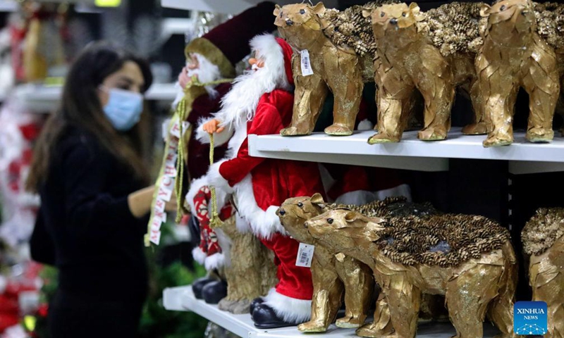 A woman shops for Christmas decorations at a store in Beirut, Lebanon, on Dec. 11, 2021.Photo:Xinhua