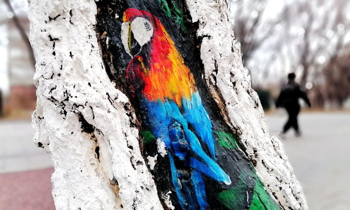 A parrot painted by university volunteers is seen on a tree trunk in Shenyang, Northeast China's Liaoning Province, along with some other 50 tree paintings along the road. Photo: IC