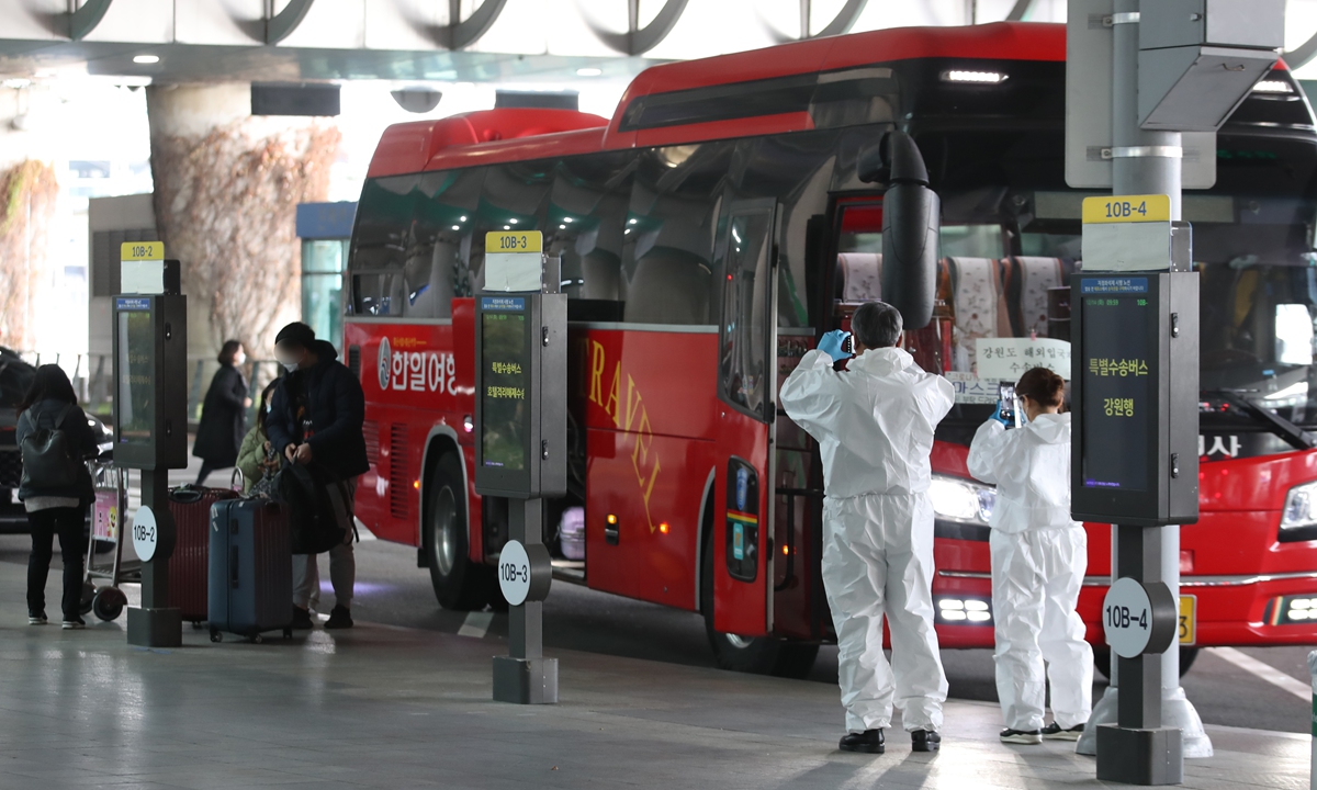 Airport staff members take pictures of a shuttle bus at Incheon International Airport, South Korea on December 14, 2021. South Korea's Ministry of Foreign Affairs stated that because of the Omicron coronavirus variant, the South Korean government decided to extend the special warning for global travel for another month. Photo: AFP