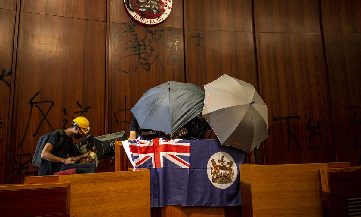 Anti-government rioters put a British colony flag inside the chamber of the Legislative Council in Hong Kong on July 1, 2019 after storming the complex. Photo: AFP