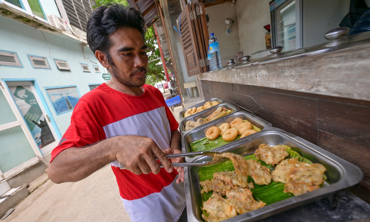 Indonesian chef Ilhani prepares fried food for customers on Gili Trawangan resort island on November 22, 2021. Photo : AFP