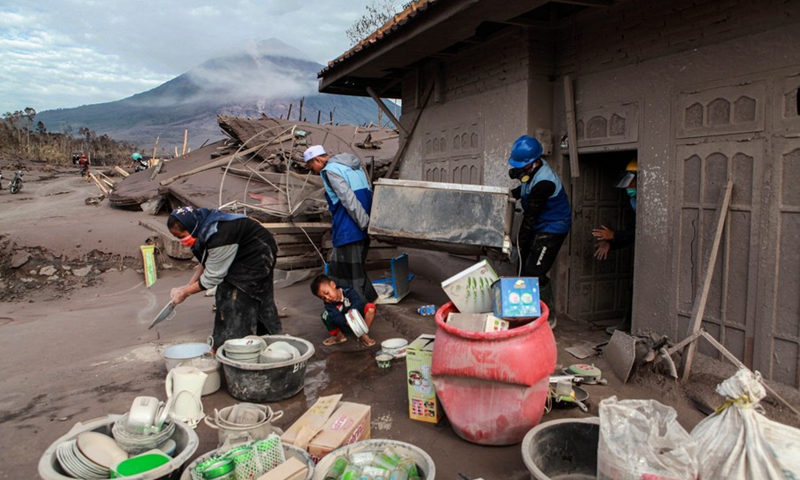 Volunteers help to move a cupboard from a house for cleaning after the Mount Semeru eruption in Sapiturang Village of Lumajang, East Java, Indonesia, Dec. 7, 2021.(Photo: Xinhua)