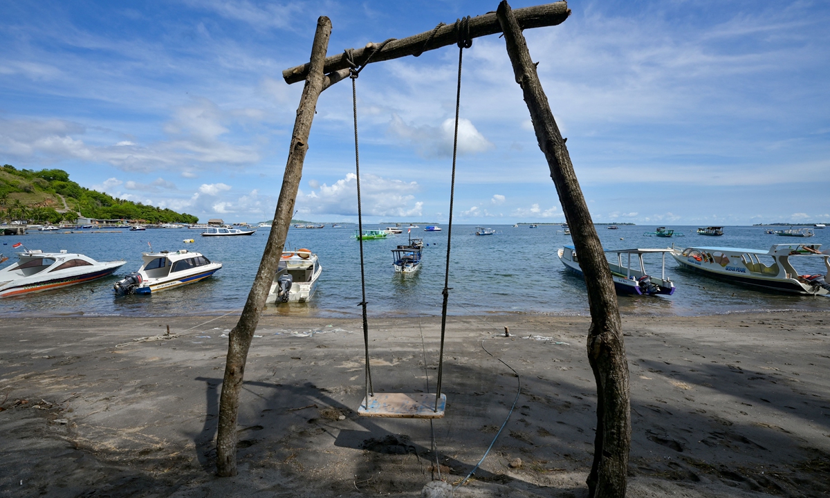 This picture taken on November 22, 2021 shows a swing near boats anchored along the shore in Pemenang on North Lombok island, where tourists used to take the ferry to Gili Trawangan.  Photo: AFP