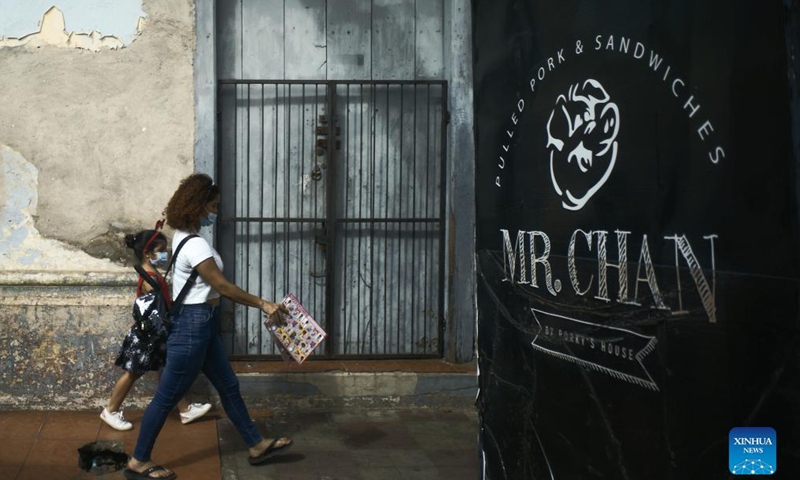 A woman and a girl walk on the street in Leon, Nicaragua, Dec. 15, 2021. Leon, the capital of the Province of Leon, is located along the Chiquito River. Leon is also the second largest city in Nicaragua and is home to the famous Leon Cathedral. (Xinhua)