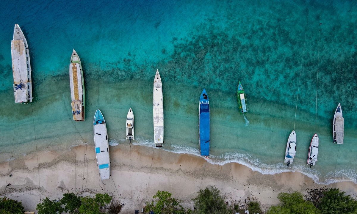 This aerial picture taken on November 22, 2021 shows boats anchored along an empty beach on Gili Trawangan resort island. Photo : AFP