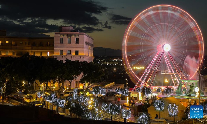 A giant ferris wheel and trees decorated with lights are seen in Malta's capital Valletta, Dec. 15, 2021. Malta's capital Valletta has been lit up with decorations as Christmas approaches.(Photo: Xinhua)