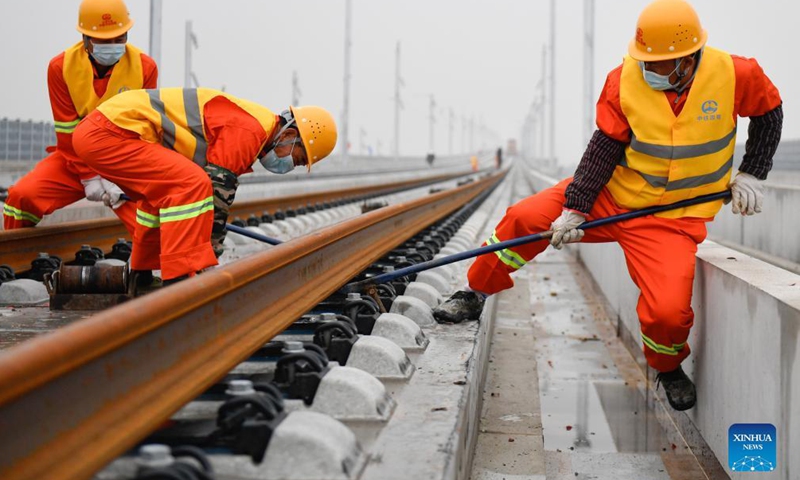Workers of the China Railway No.4 Engineering Group lay the track of the Huzhou-Hangzhou high-speed railway in Yuhang District, Hangzhou City of east China's Zhejiang Province, Dec. 16, 2021.Photo:Xinhua