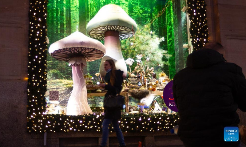 A woman walks past a window display with Christmas decorations in Amsterdam, the Netherlands, on Dec. 18, 2021.Photo:Xinhua