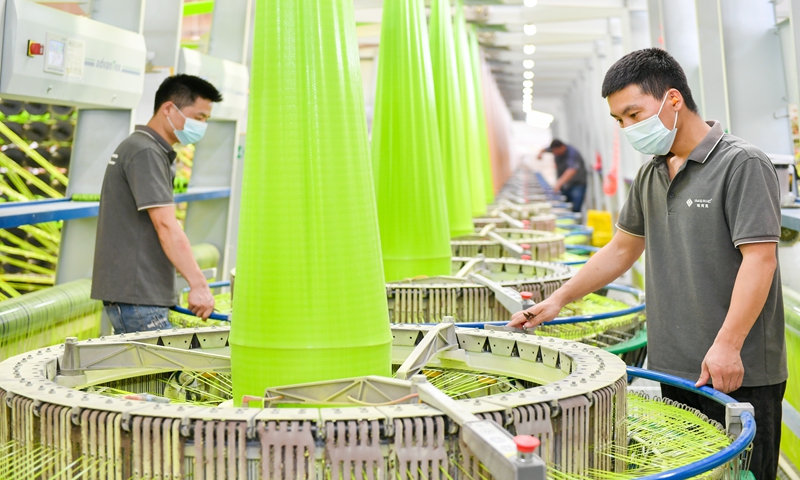 Employees work on a high-speed circular weaving machine assembly line at a workshop in Changxing Economic and Technological Development Zone in Huzhou, East China's Zhejiang Province, on June 18, 2020. Photo: VCG