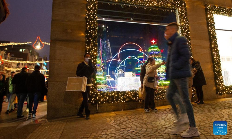 People walk on a street with Christmas decorations in Amsterdam, the Netherlands, on Dec. 18, 2021.Photo:Xinhua