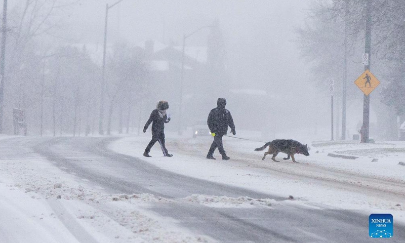 People cross a street during a snowy day in Mississauga, the Greater Toronto Area, Canada, on Dec. 18, 2021.Photo:Xinhua