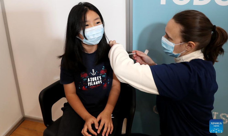 A child receives a dose of the COVID-19 vaccine at a vaccination center in Cascais, Portugal, on Dec. 18, 2021.Photo:Xinhua