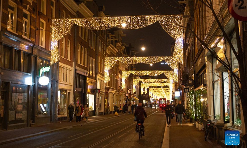 People walk on a street with Christmas decorations in Amsterdam, the Netherlands, on Dec. 18, 2021.Photo:Xinhua