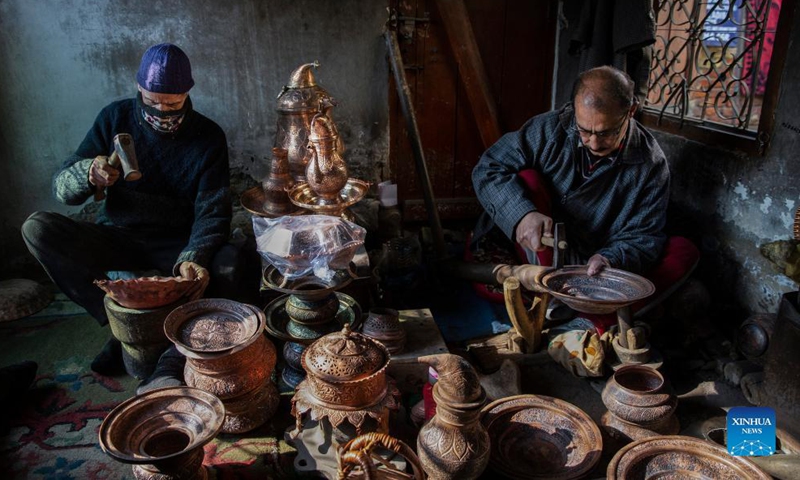 Coppersmiths make copper pots at a workshop in Srinagar city, the summer capital of Indian-controlled Kashmir, Dec. 18, 2021.Photo:Xinhua