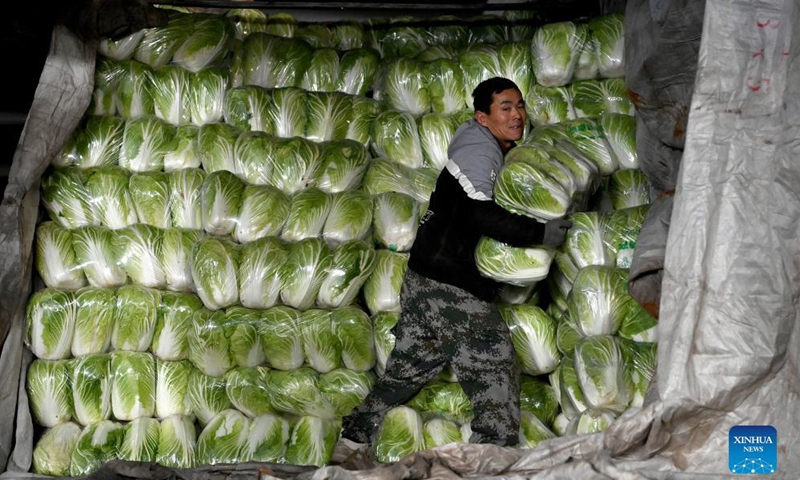 A staff member carries vegetable at a logistics center in Xi'an, northwest China's Shaanxi Province, Dec. 19, 2021.Photo:Xinhua